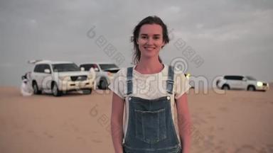在阿拉伯联合酋长国，一辆沙漠旅游观光车的背景上摆着一个快乐的女孩。